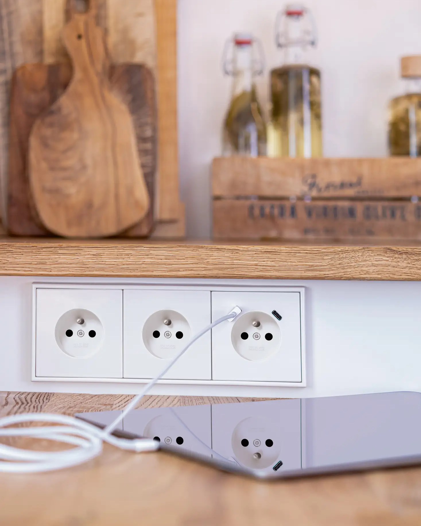 Jung triple socket plate with a USB-C port, phone charging cable plugged in
