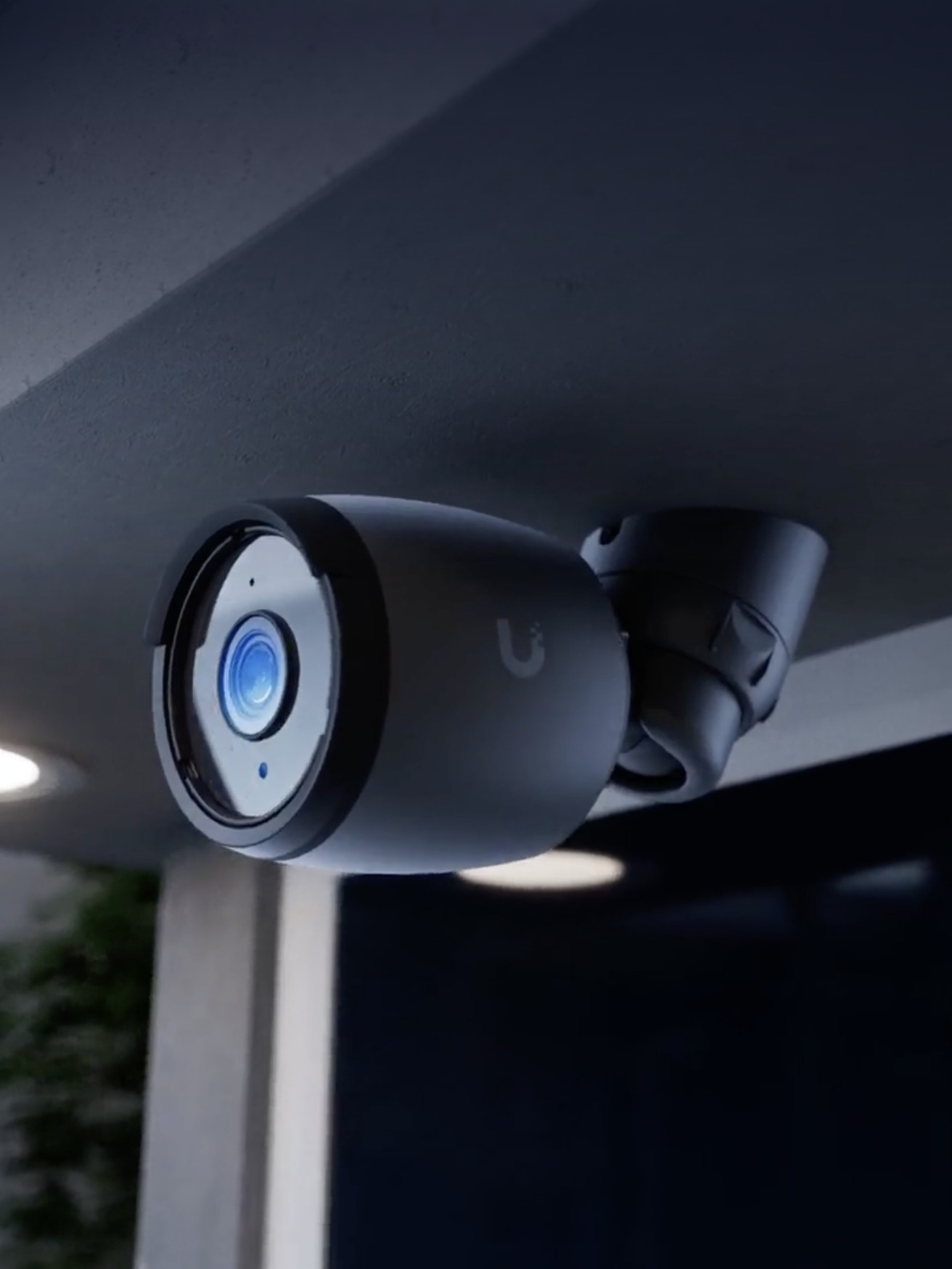 UniFi bullet camera mounted under an eave at night